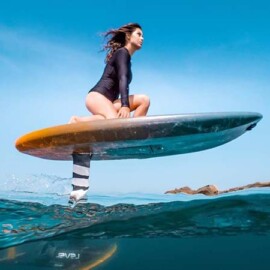 A woman skillfully rides a surfboard on the waves of Maui ocean, showcasing her surfing prowess and connection with nature.