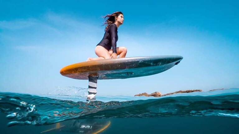 A woman skillfully rides a surfboard on the waves of Maui ocean, showcasing her surfing prowess and connection with nature.