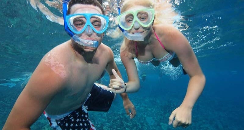 Couple snorkeling underwater at a tropical reef, showcasing marine life adventure for Top 5 Hidden Snorkeling Reefs You Can Only Reach by Kayak