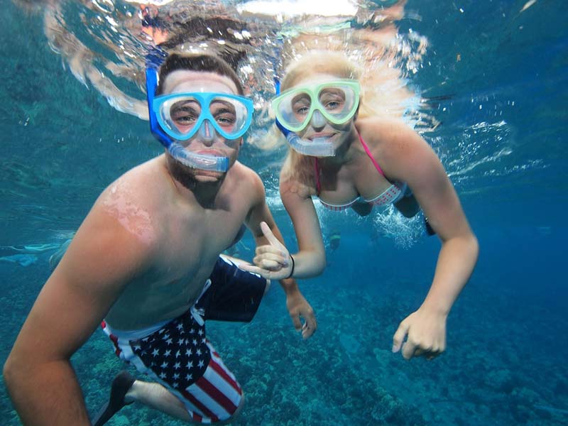 Couple snorkeling underwater at a tropical reef, showcasing marine life adventure for Top 5 Hidden Snorkeling Reefs You Can Only Reach by Kayak