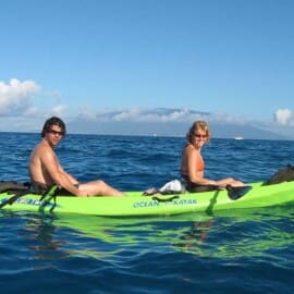 A couple kayaking on the clear blue ocean during Maui in October, enjoying warm weather and outdoor adventures.